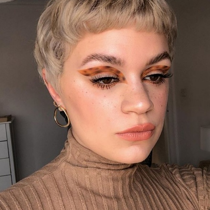 chica rubia con cabello corto con maquillaje de animal print