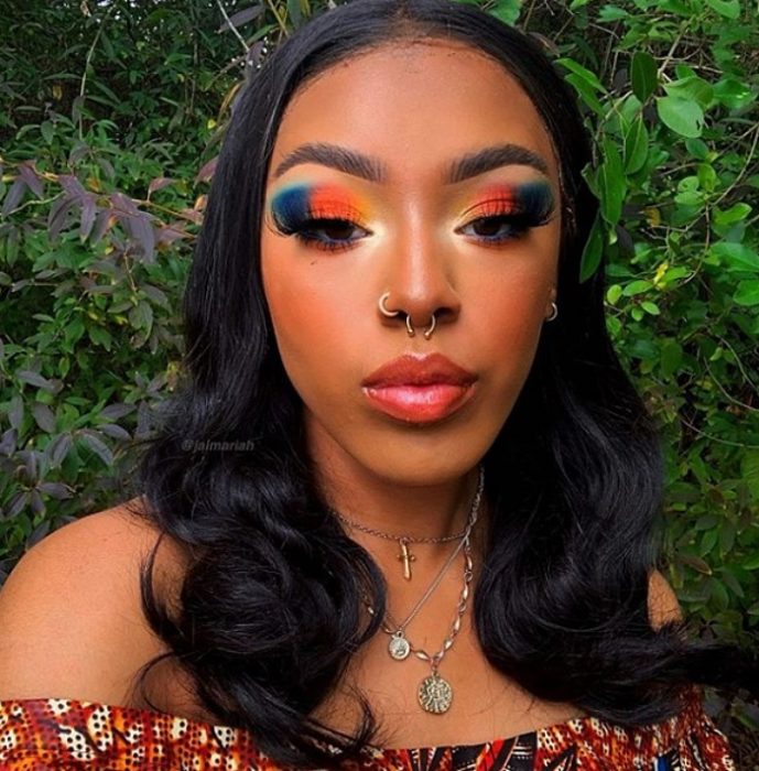 chica morena con cabello largo oscuro usando maquillaje de colores brillantes que contrastan con su tono de piel