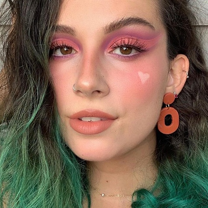 chica con cabello teñido de verde, usando maquillaje en colores rosa pastel