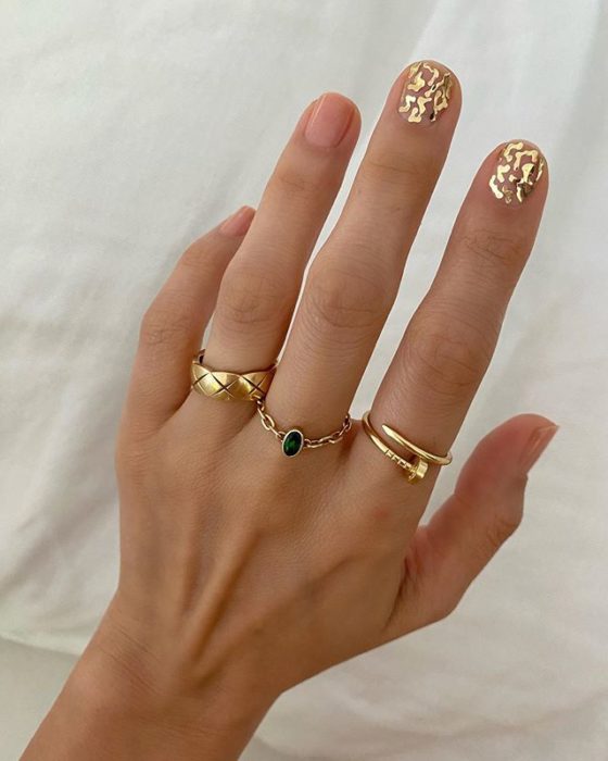 Diseños de uñas de Betina Goldstein con pequeñas estrellas doradas solo en el dedo índice y medio