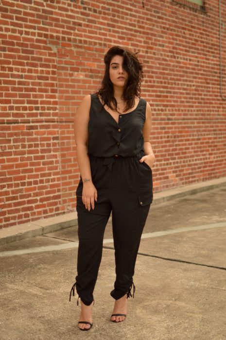 Chica curvy usando un pantalón estilo cargo con una blusa negra y tacones