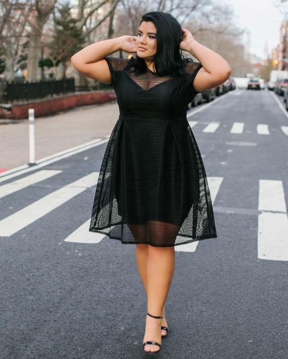 Chica curvy usando un vestido de color negro con transparencias