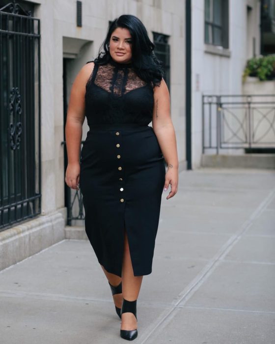 Chica curvy con un vestido negro de botones y encaje en el pecho de color negro