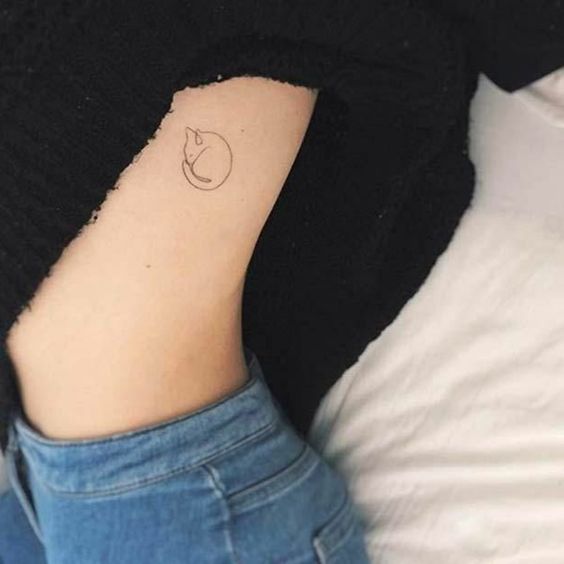 Tatuaje de gato enrollado en tinta negra en las costillas