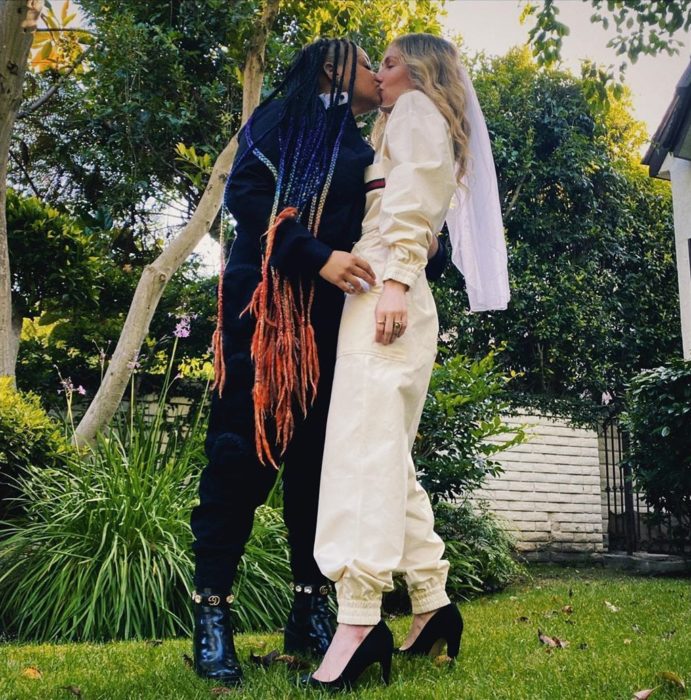Raven-Symoné y Miranda Maday besándose para celebrar su boda secreta en el patio de su casa