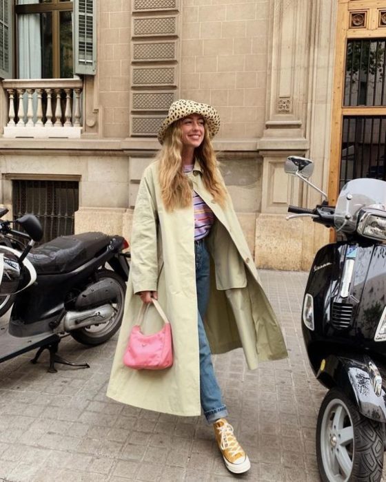 Chica con gabardina en tono verde limón y sombrero estilo pescador