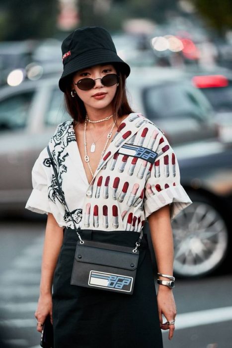 Chica con falda negra y camisa de estampados de labiales