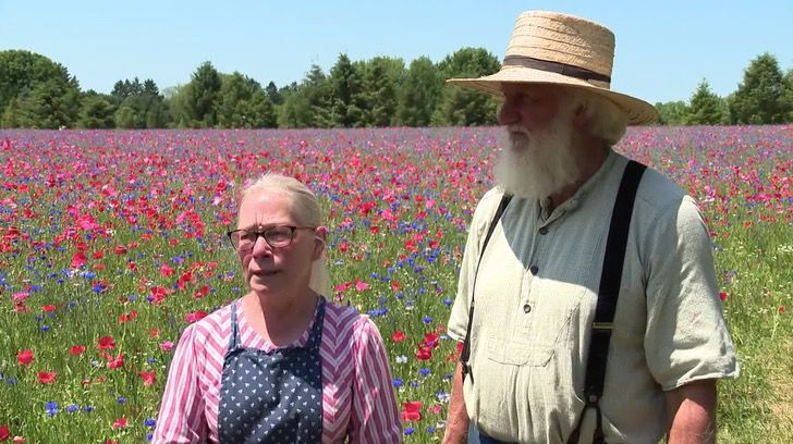 Joan Donaldson y John Van Voorhees mostrando su campo cubierto de amapolas
