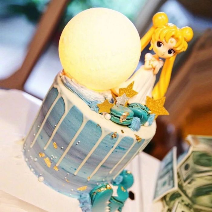 Pastel de Sailor Moon con Serena y una luna enorme, en tonalidades azules y chorreado de chocolate