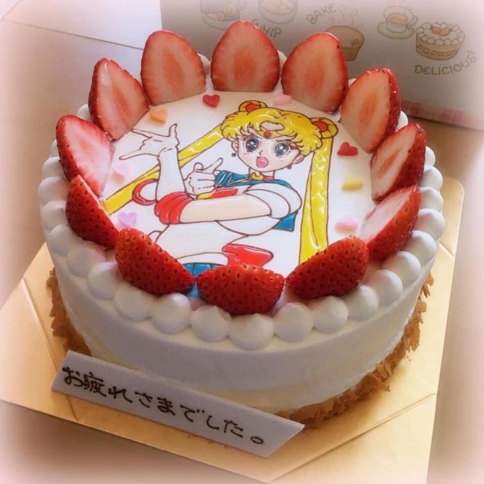 Pastel de Sailor Moon con Serena al fondo, decorado con fresas cortadas por la mitad alrededor