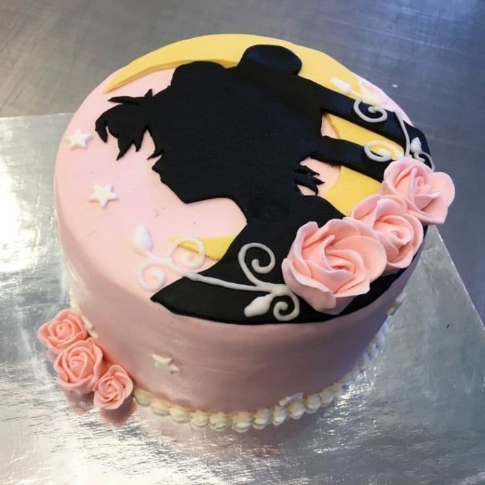 Pastel de Sailor Moon en forma de la silueta del rostro de Serena, decorado con algunas rosas de betún