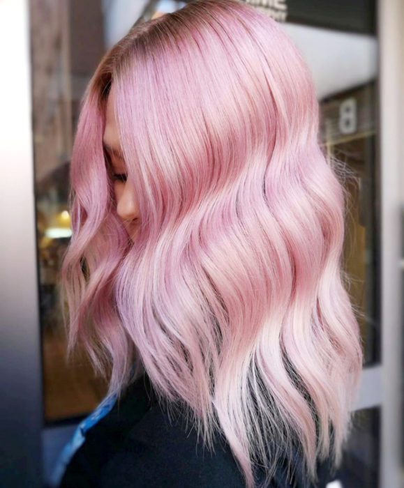 Cabello color rosa cherry blossom; mujer de cabello teñido, largo y ondulado