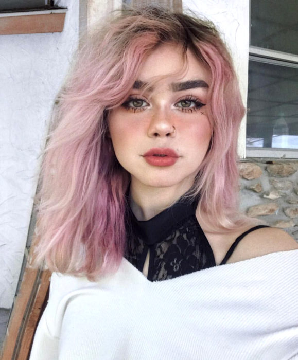 Cabello color rosa cherry blossom; chica de ojos verdes con cabello despeinado hasta los hombros, perforación en la nariz