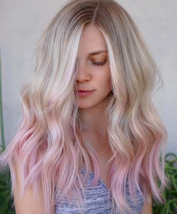Cabello color rosa cherry blossom; mujer sonriendo con los ojos cerrados, cabello rubio y teñido en las puntas, ombré