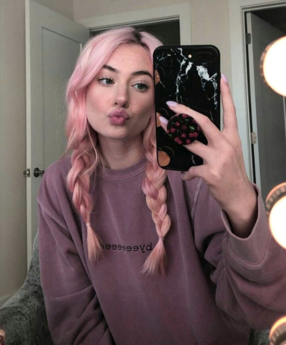 Cabello color rosa cherry blossom; chica tomándose un selfie frente al espejo, con cabello peinado con trenzas, duck face