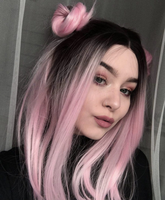 Cabello color rosa cherry blossom; chica de ojos verdes, con cabello lacio y largo, peinado con chonguitos altos, perforación en la nariz