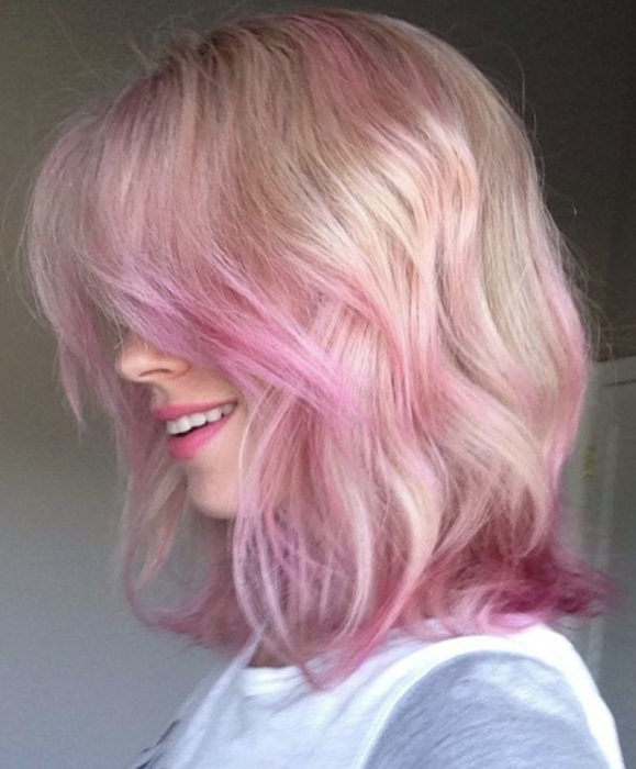 Cabello color rosa cherry blossom; mujer de perfil sonriendo, con cabello rubio y teñido en las puntas