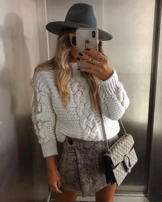 chica con suéter y skort, sombrero y bolso