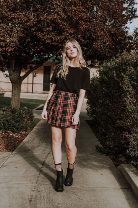 chica con skort y camiseta negra, tenis y calcetines