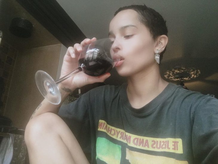Zoë Kravitz con el cabello corto disfrutando de una copa de vino