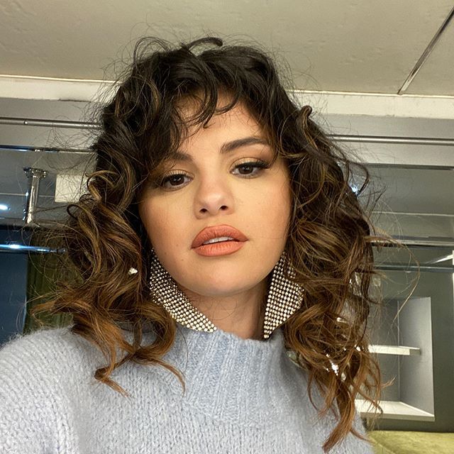 Selena Gomez con el cabello rizado y con flequillo