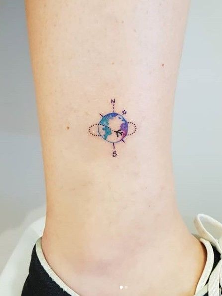 Tatuaje pequeño de planeta tierra con una brújula