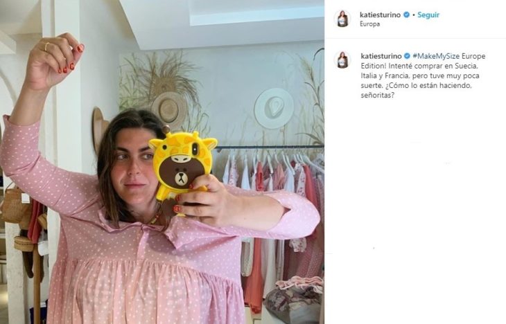 Katie Sturino tomando una selfie dentro de un probador con un vestido rosa claro que no corresponde a su talla
