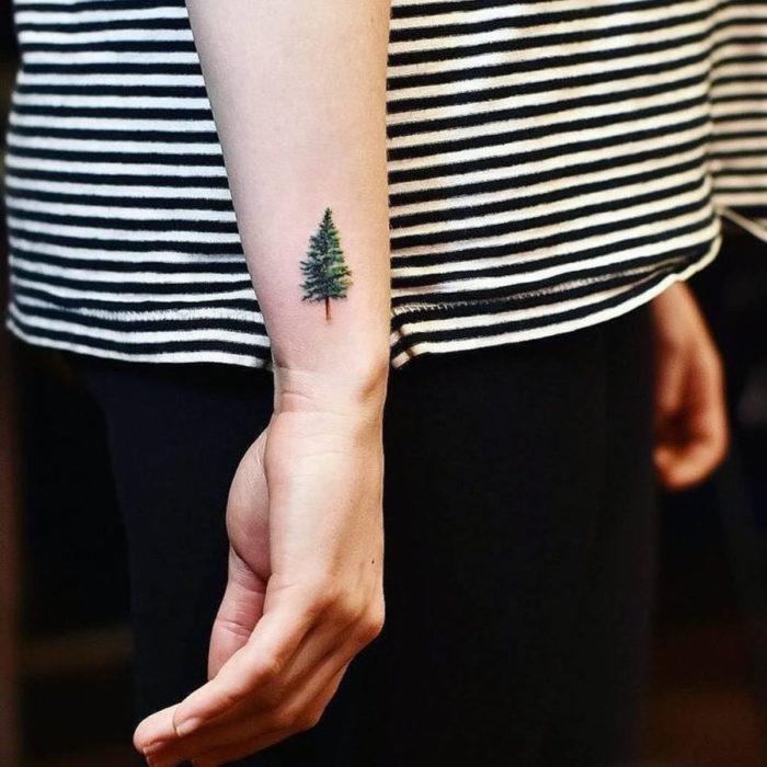 Tatuajes pequeños en la muñeca; árbol de pino