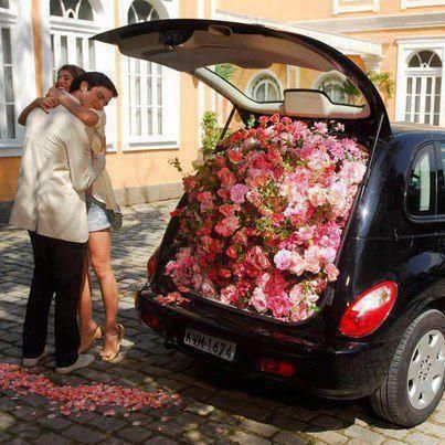 Chico obsequia a chica miles de flores en la cajuela de un coche azul