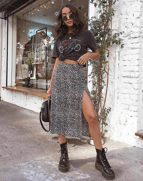 Chica con falda larga con corte lateral y blusa negra anudada en la cintura