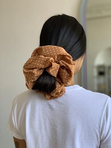 Chica con cabello negro y scrunchie gigante naranja