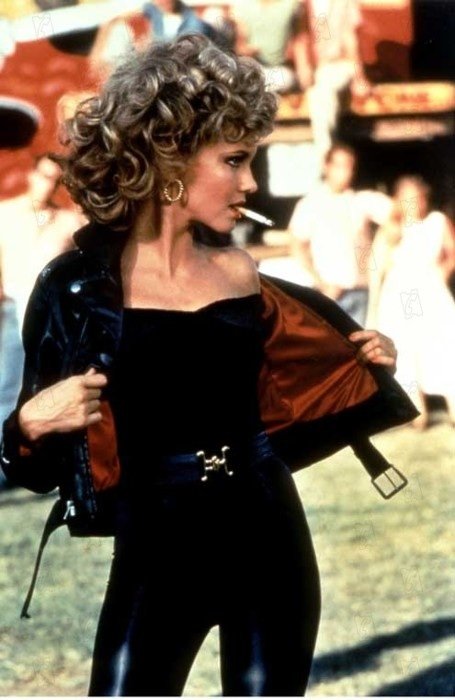 Olivia Newton John usando un traje negro en la película Vaselina