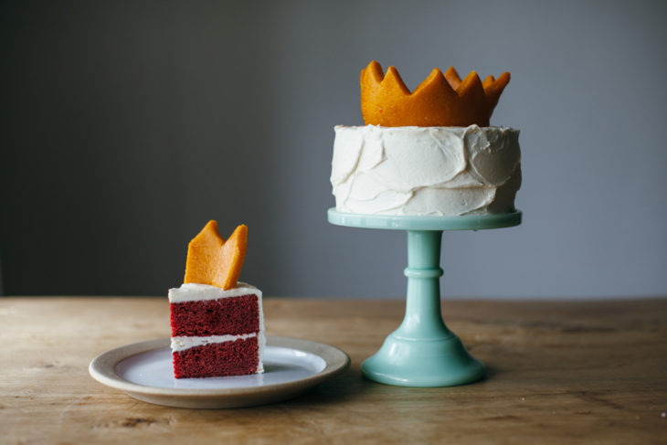 Pastel red velvet con betún de vainilla y una corona amarilla
