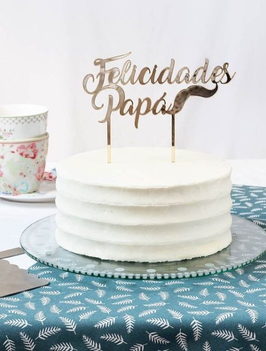Pastel de vainilla decorado con banderilla que dice felicidades papá