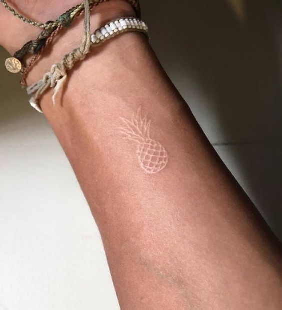 Tatuaje de piña con tinta blanca