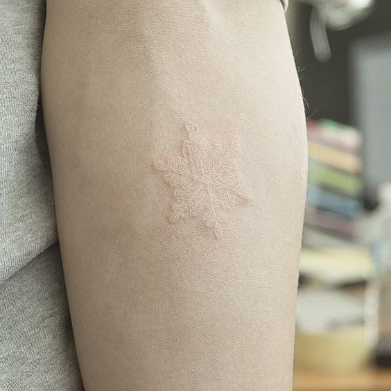Tatuaje de copo de nieve con tinta blanca