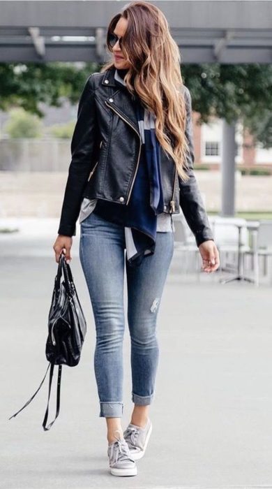 Chica con un outfit inspirado en Lara Jean que consiste en jeans y chaqueta de cuero