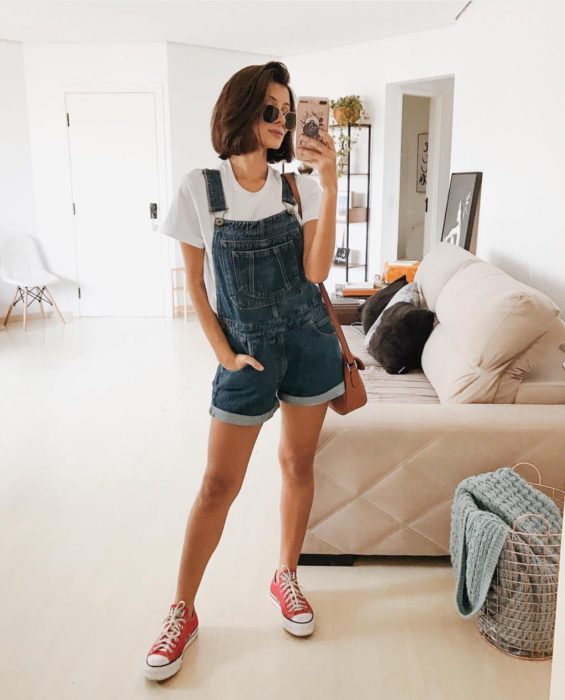 Chica con un outfit inspirado en Lara Jean que incluye overol de mezclilla y tenis