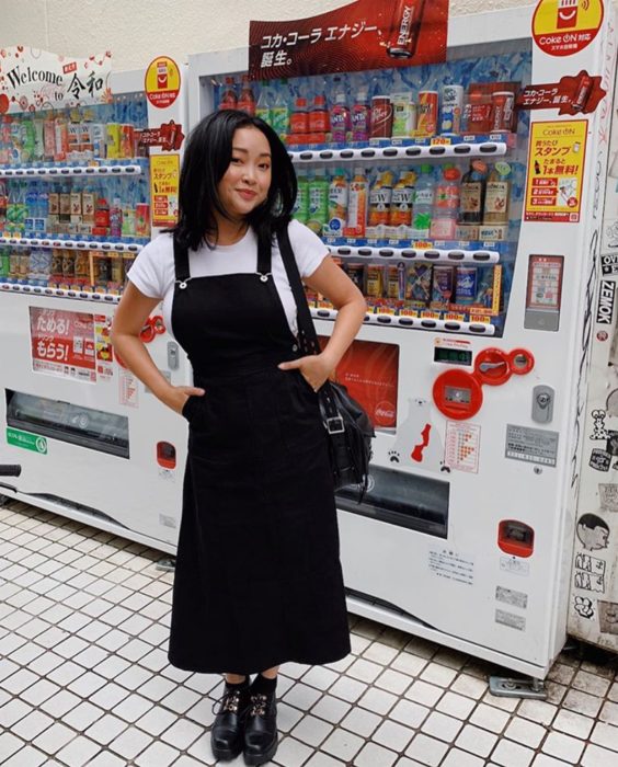 Chica con un outfit inspirado en Lara Jean que incluye un overol negro con botines
