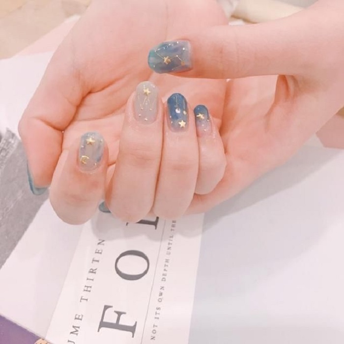 Diseño de manicura en tonalidades azul cielo y detalles dorados