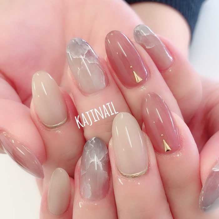 Diseño de manicura en tonos rosa, beige y azul con detalles dorados