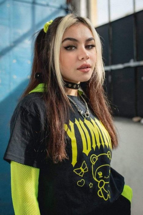 Chica de cabello largo con dos coletas lleva mechones de cabello blancos 