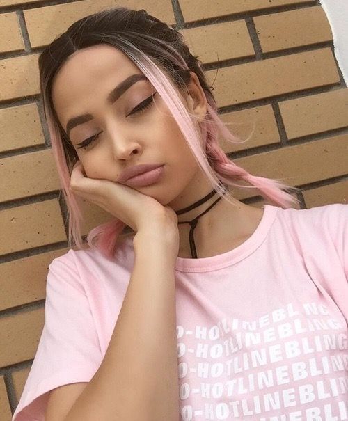 Chica morena con trenzas y mechones de cabello rosa