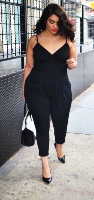 Chica curvy usando un atuendo que resalta sus curvas en color negro