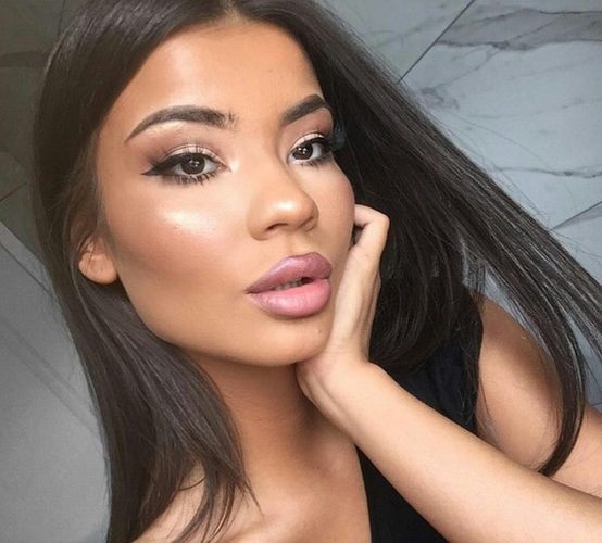 Chica morena con cabello suelto y labial matte rosa