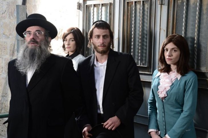 Elenco de la serie Shtisel reunidos frente a una ventana con cortina blanca