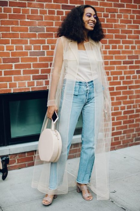 Chica usando jeans y top blanco con un ensamble de transparencia color hueso