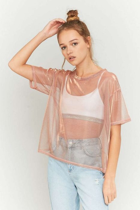 Chica usando top blanco y blusa de transparencias en tono rosado