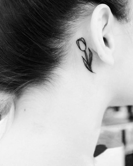 Chica con un tatuaje de tulipán detrás de las orejas 