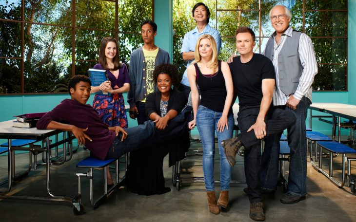 Elenco de la serie Community reunidos en un comedor comunitario sonriendo